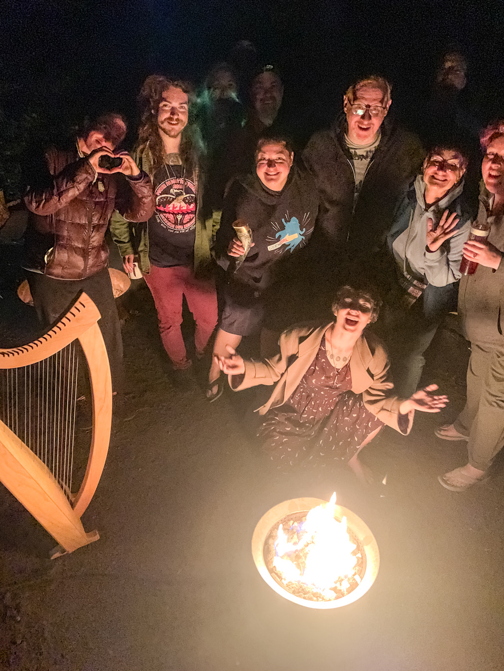 overhead view of eight people around a campfire with a small harp