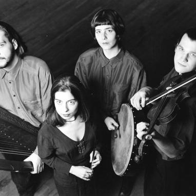 black and white image of four people holding instruments